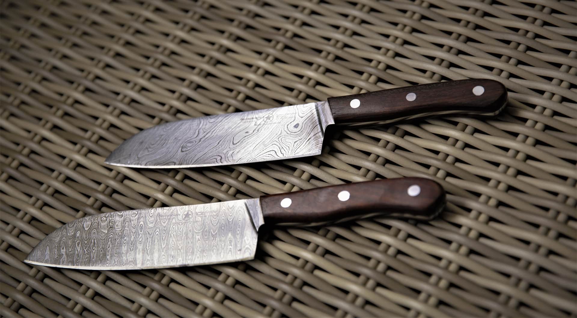 Two kitchen knives laid side by side on wood