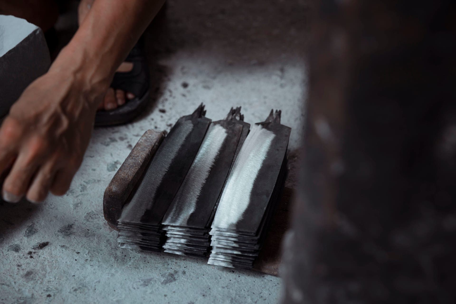 A Japanese gyuto blade on a dark surface, edge catching the light
